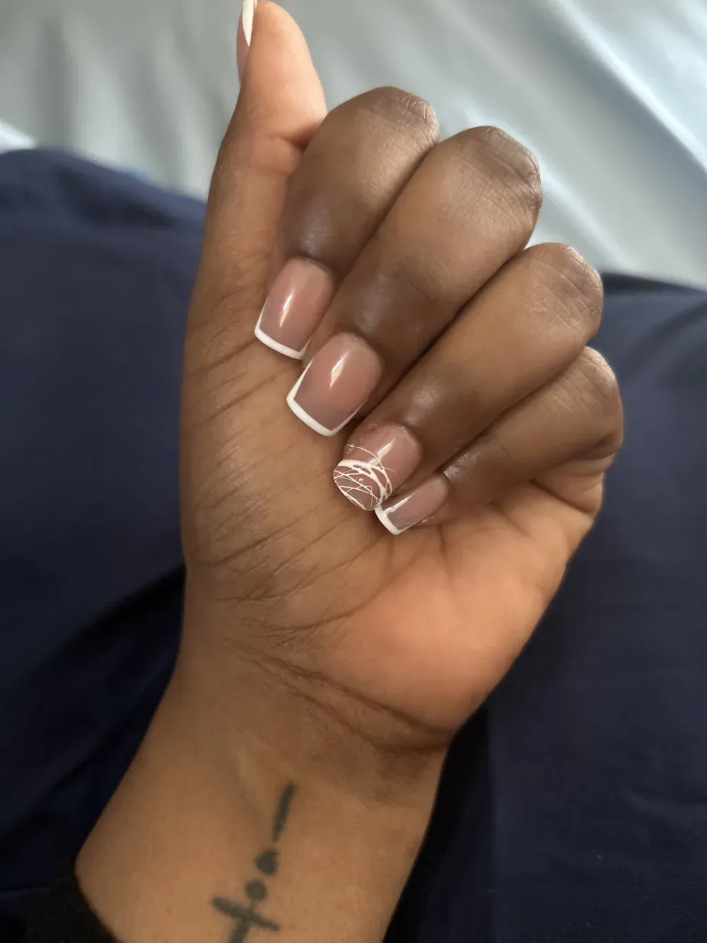 Clean nude and white French tips with a fine white line-art accent nail