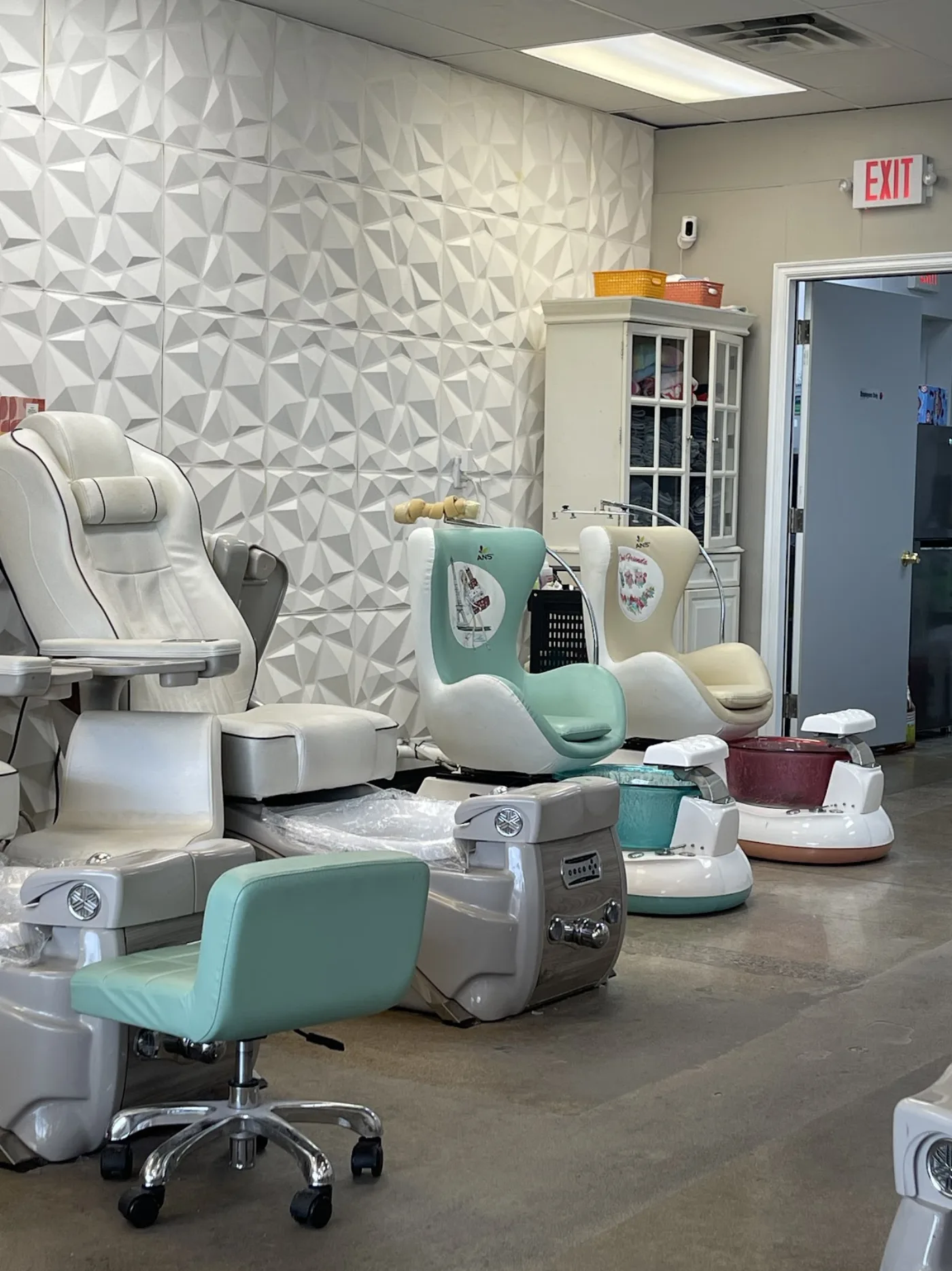 Inside Magic Nailspa: white and mint pedicure massage chairs against a sculpted 3D wall